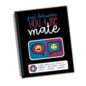 Puede incluir: Un cuaderno negro de espiral con el texto "just between you & me mate" en blanco. La portada también presenta dos burbujas de diálogo con caras sonrientes, una azul y otra rosa. El texto "BACK & FORTH Journal designed for roommates mate mates siblings besties frenemies coworkers" está impreso en blanco en la parte inferior.