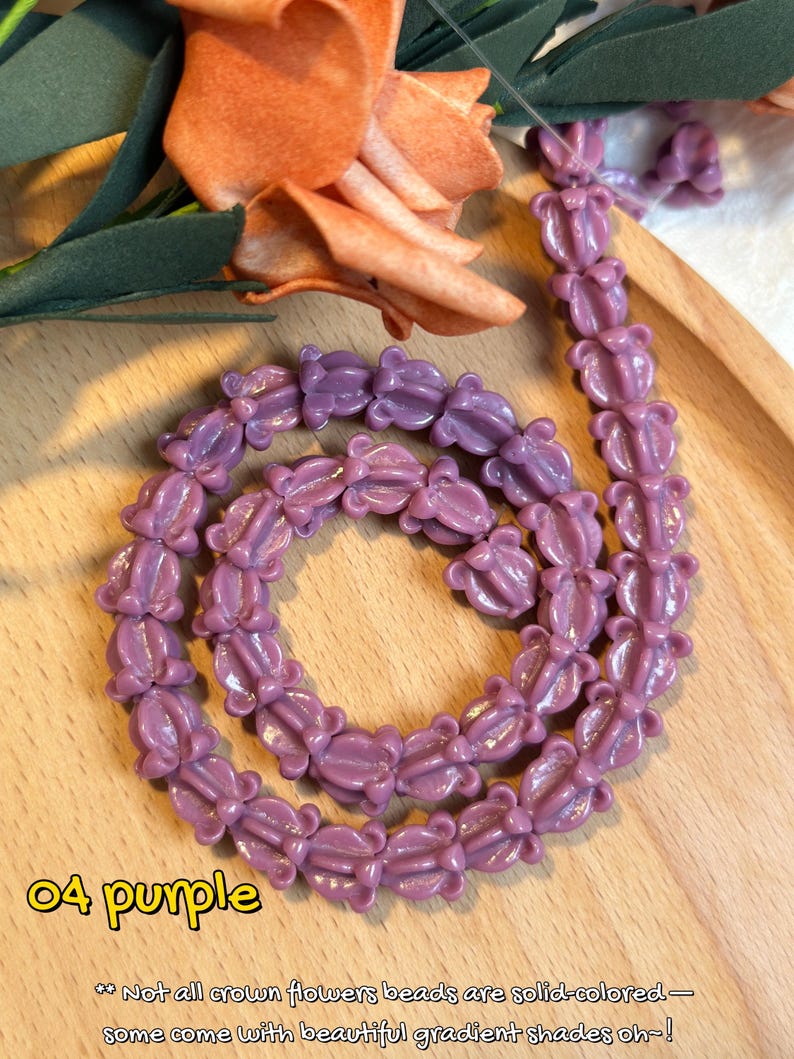 May include: A strand of purple flower-shaped beads. The beads are arranged in a circular pattern on a wooden tray. The text "04 purple" is in the lower left corner. The text below reads "Not all crown flowers beads are solid-colored - some come with beautiful gradient shades oh~!"