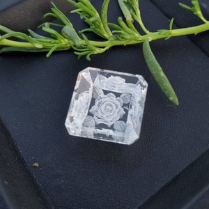 May include: A clear glass cube with a white rose and leaves etched into the surface.