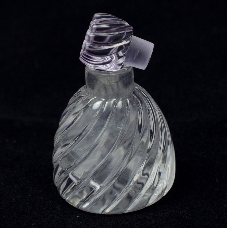 May include: A clear glass bottle with a swirl design and a purple glass stopper.