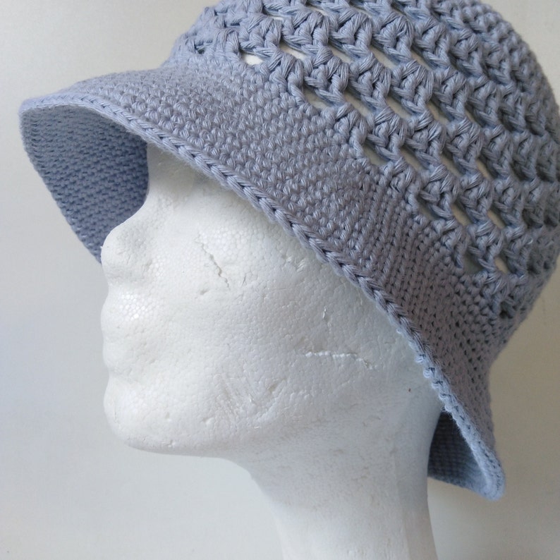 Peut inclure: Un chapeau de soleil en crochet bleu clair avec un large bord et un motif ajour&eacute;.