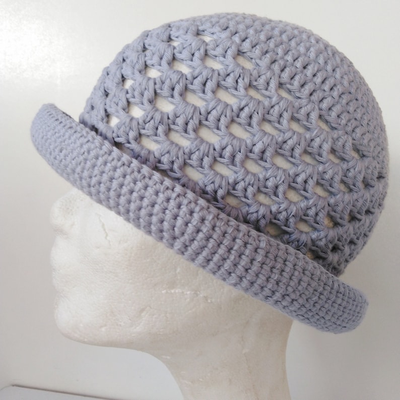 Peut inclure: Un chapeau crochet&eacute; gris clair avec un large bord et un motif en maille ouverte.
