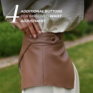 May include: A brown leather waist belt with a button closure. The belt has a unique design with a flap detail and is shown with the text "4 ADDITIONAL BUTTONS FOR IMPROVED WAIST ADJUSTMENT".