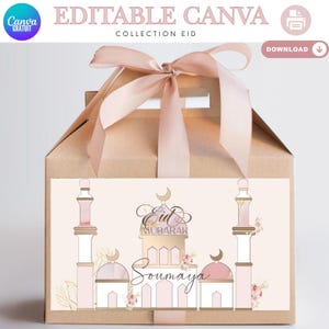 Può includere: Una scatola regalo marrone con un nastro rosa e un manico. La parte anteriore presenta un disegno con illustrazioni di moschee, le parole "Eid Mubarak" e "Soumaya". La scatola fa parte della "Collection Eid".