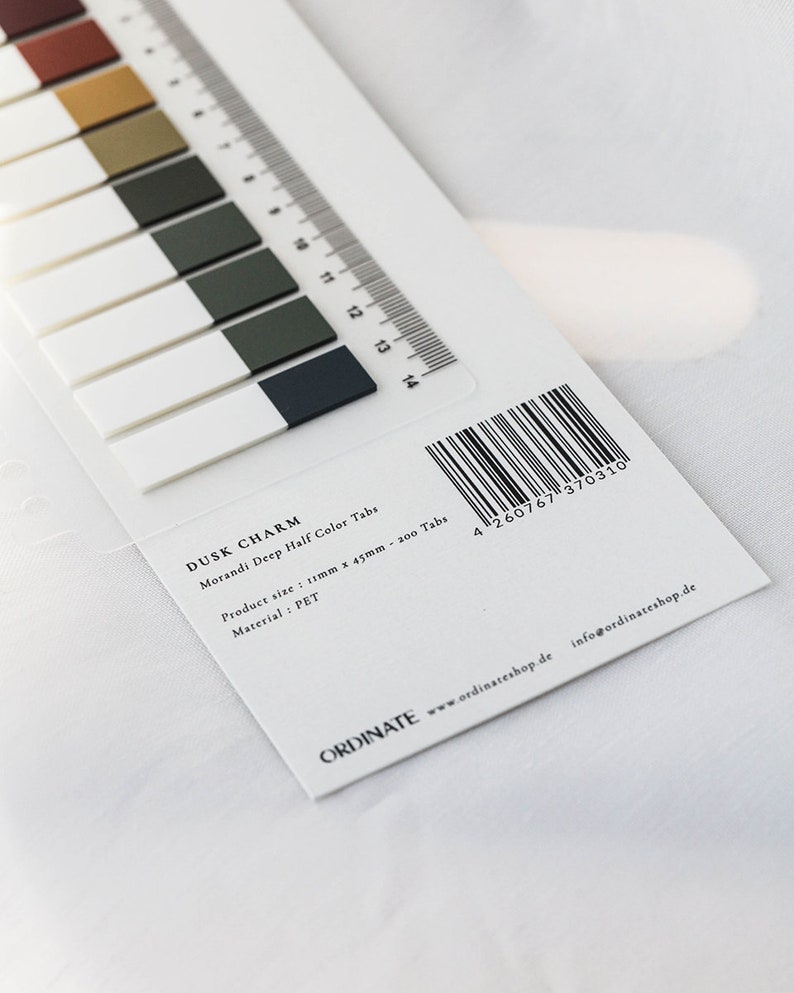 May include: A package of "Dusk Charm" Morandi Deep Half Color Tabs. The tabs are rectangular, with a white base and a colored top in shades of brown, green, and navy. A ruler is printed along the edge. The product size is 11mm x 45mm.