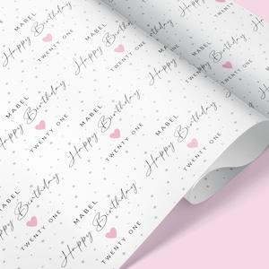 May include: White wrapping paper with a repeating pattern of pink hearts and the text "Mabel Happy Birthday Twenty One".