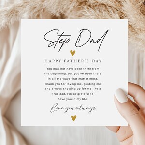May include: A white Father's Day card with the words "Step Dad" in elegant script, and a heartfelt message. The card features gold heart accents and is held by a person.