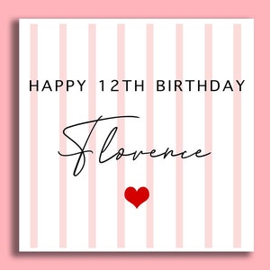 May include: A white card with pink stripes and the text "Happy 12th Birthday Florence" in black. A red heart is below the text.