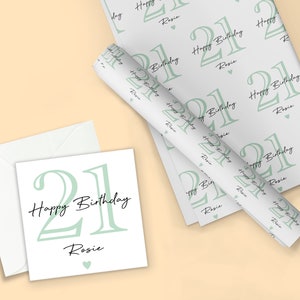 May include: A birthday-themed set featuring a greeting card, envelope, and wrapping paper. The design includes the number "21", the words "Happy Birthday", and the name "Rosie" in a soft green and black color scheme.