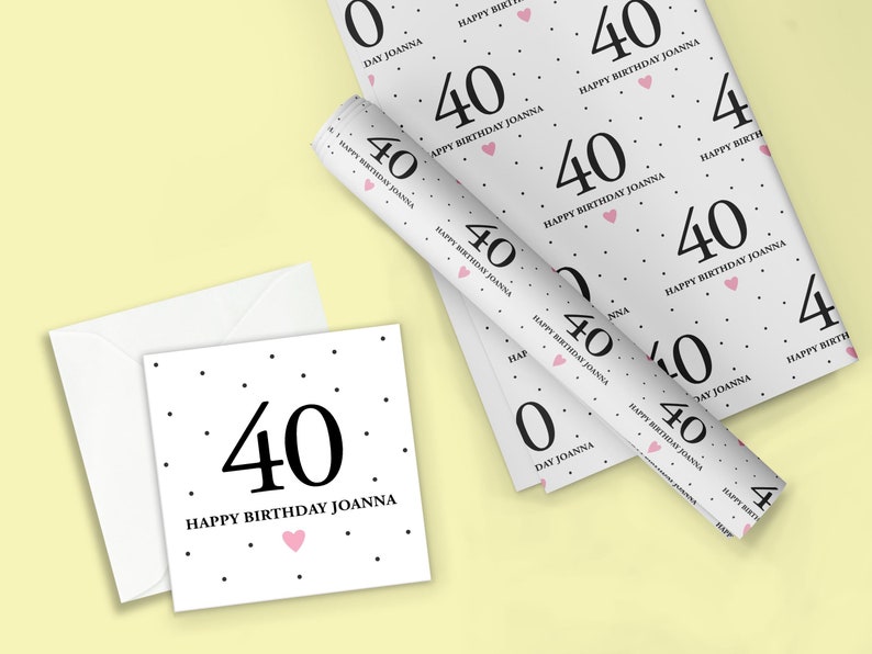 May include: White wrapping paper with a black polka dot pattern and the text "Happy Birthday Joanna" and the number "40" repeated. A pink heart is also included in the design.