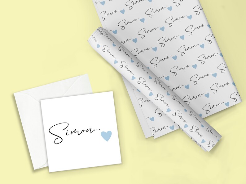 Pu&ograve; includere: Carta da regalo bianca con un motivo ripetuto del nome "Simon" in scrittura nera con un cuore blu chiaro dopo ogni nome. &Egrave; mostrata anche una carta bianca con il nome "Simon" in scrittura nera e un cuore blu chiaro.