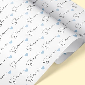 Pu&ograve; includere: Carta da regalo bianca con un motivo ripetuto di cuori blu chiaro e il nome "Simon..." scritto in corsivo nero.