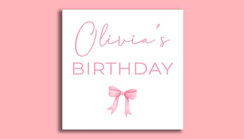 May include: A white card with pink text that reads "Olivia's Birthday" and a pink bow.