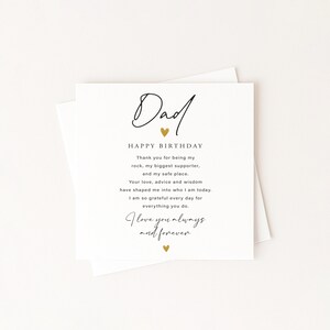 May include: A white greeting card with the word "Dad" in elegant script, a gold heart, and the words "Happy Birthday." The card includes a heartfelt message expressing gratitude and love. The card is on a white background.
