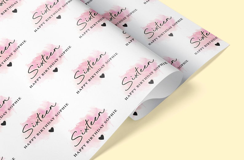 May include: White wrapping paper with a pink watercolor design and the text "Sixteen Happy Birthday Sophie" repeated throughout.
