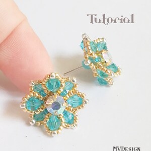 May include: A pair of turquoise and gold beaded earrings with a clear crystal in the center. The earrings are in the shape of a flower.