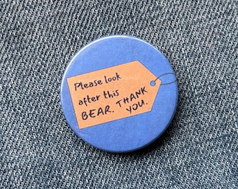 Insignia inspirada en el musical de Paddington: por favor, cuiden de este oso.