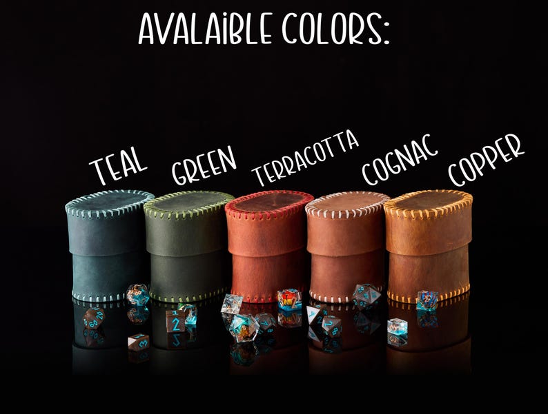 May include: Five cylindrical leather dice cases with stitched edges, labeled with the text AVALAIBLE COLORS: TEAL, GREEN, TERRACOTTA, COGNAC, and COPPER. Each case is accompanied by a small collection of multi-faceted polyhedral dice in various colors.