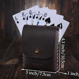 Puede incluir: Un porta tarjetas de cuero marr&oacute;n con detalles de costura. El porta tarjetas mide 10,5 cm de alto, 7,5 cm de ancho y 2,5 cm de profundidad. El porta tarjetas se muestra con cartas de juego en su interior.