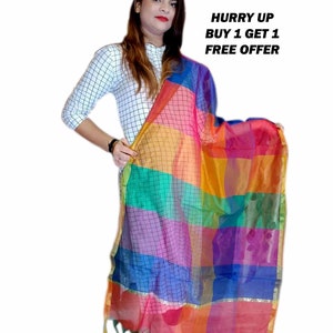 Peut inclure: Un châle à carreaux coloré avec des bordures dorées et des glands. Le châle est fait d'un tissu transparent et présente un motif arc-en-ciel. Le texte "HURRY UP BUY 1 GET 1 FREE OFFER" est visible sur l'image.