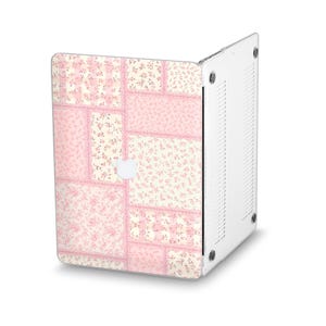 Peut inclure: Une coque d'ordinateur portable avec un motif patchwork. L'&eacute;tui pr&eacute;sente un motif de carr&eacute;s de tissu floral roses et cr&egrave;me. Le logo Apple blanc de l'ordinateur portable est visible. L'&eacute;tui est fait d'un mat&eacute;riau transparent et protecteur.