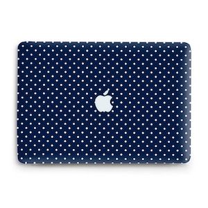 May include: A navy blue laptop cover with a white polka dot pattern. The Apple logo is centered on the cover. The cover is rectangular and has rounded corners.