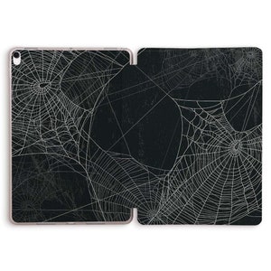 Pode incluir: Uma capa para iPad preta e branca com um design de teia de aranha. A capa é feita de um material durável e tem um visual elegante e moderno.