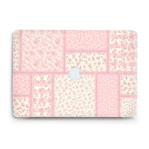 May include: A laptop skin with a patchwork design in shades of pink and cream. The pattern includes floral motifs and lace-style borders. The Apple logo is centrally placed on the skin.