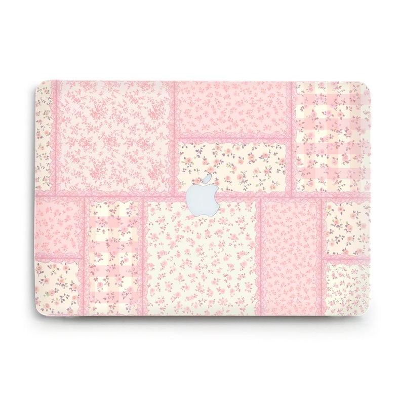 Peut inclure: Une peau d'ordinateur portable avec un motif patchwork floral rose et cr&egrave;me. Le design pr&eacute;sente des panneaux rectangulaires avec diff&eacute;rents motifs floraux et des bordures en dentelle. Le logo Apple est visible.