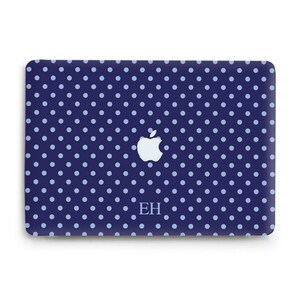 May include: A dark blue laptop skin featuring a repeating pattern of light blue polka dots. The center displays a white Apple logo, and the letters EH are printed in a light blue serif font below the logo on the rectangular surface.