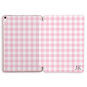 May include: Pink and white gingham pattern tablet case, open to display the interior. The case has a hard shell design and features the initials "JK" in the lower right corner. The case is designed to protect the tablet from scratches and damage.