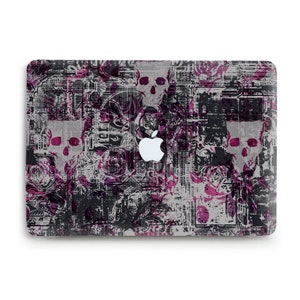 May include: A laptop skin with a black, white, and pink abstract design featuring skulls and floral patterns.