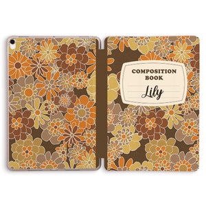 May include: A brown and orange floral patterned iPad case with a brown spine. The back of the case has a white label with the text "COMPOSITION BOOK Lily".