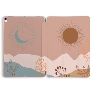 May include: A pink and brown iPad case with a sun and moon design. The case features a minimalist design with a sun and moon in the center and a mountain range in the background. The case is made of a soft, durable material and is perfect for protecting your iPad.