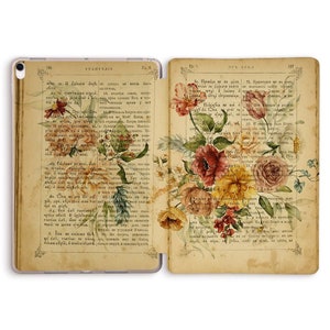 Könnte beinhalten: Ein Vintage-Buch mit einem floralen Design auf dem Einband. Das Buch ist auf einer Seite mit Text in einer Fremdsprache aufgeschlagen. Die Blumen sind in Rosa-, Rot-, Gelb- und Weißtönen gemalt.