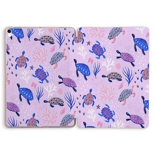 May include: A purple iPad case with a repeating pattern of blue and pink sea turtles, coral, and seaweed.