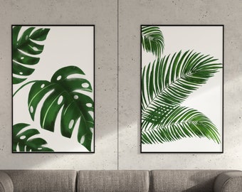 Könnte beinhalten: Zwei gerahmte botanische Drucke mit grünen tropischen Blättern auf weißem Hintergrund. Ein Druck zeigt Monstera-Blätter, der andere Palmfarn. Die Drucke werden über einem grauen Ecksofa in einem modernen Wohnzimmer präsentiert.