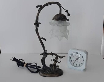 Vintage beautiful metal table lamp with a cherub on a swing