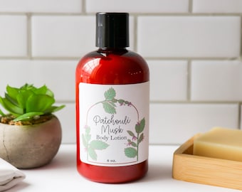 May include: A red bottle of Patchouli Musk body lotion with a white label featuring a floral design and the text "Patchouli Musk Body Lotion 8 oz."