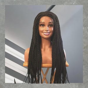 May include: A long, dark brown wig featuring uniform box braids that fall past the shoulders. The wig is displayed on a smooth, light-toned mannequin head and neck, showcasing a center part and consistent braiding throughout the entire length.