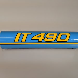 May include: A blue and yellow handlebar pad with the text "IT 490" printed on it.