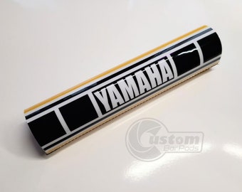 May include: Yellow and black handlebar pad with the word "YAMAHA" printed in white.