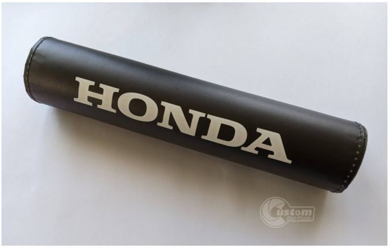 May include: Black handlebar pad with white HONDA lettering.