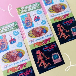 Può includere: Tre fogli di adesivi con illustrazioni colorate. Ogni foglio presenta un tema robotico con il testo "Robot Sticker", "Please Rewire Me" e "You Grind My Gears". Gli adesivi includono figure di robot, mani e grafica computerizzata.