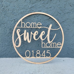 May include: A wooden round sign with the text "home sweet home" and the number "01845" in a cursive font.