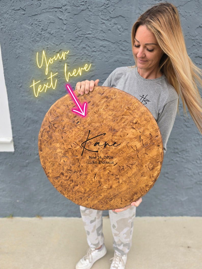 A woman is holding a large wooden plaque with the name "Karen" written on it. The plaque has a personalized message and a date, indicating it is a custom-made item for someone named Karen.