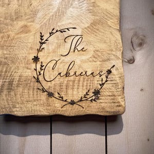 a wooden cutting board with the name "The Cubbie" engraved on it.