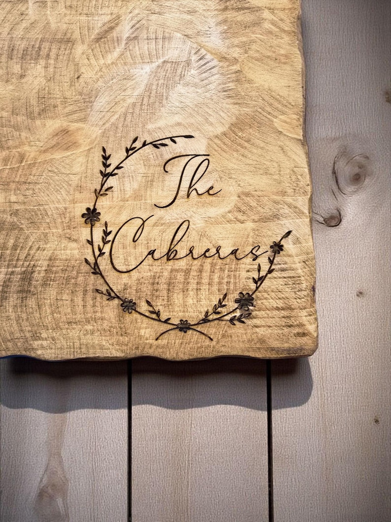a wooden cutting board with the name "The Cubbie" engraved on it.