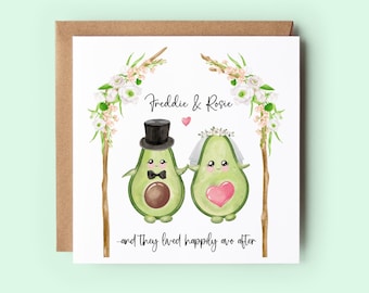 May include: A white card with a watercolor illustration of two avocados dressed as a bride and groom. The avocados are under a floral arch and the text reads "Freddie & Rosie - and they lived happily ever after".