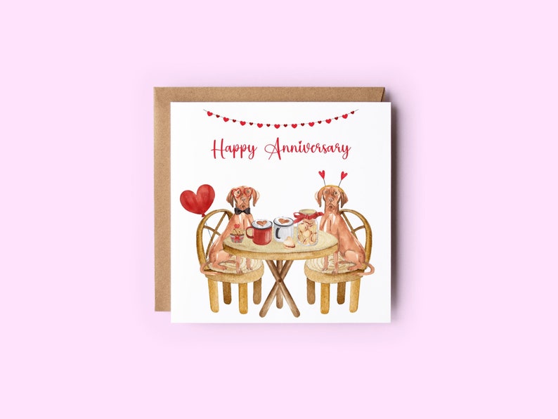 K&ouml;nnte beinhalten: Eine Gru&szlig;karte mit einer Aquarell-Illustration von zwei Hunden, die an einem Tisch mit einem herzf&ouml;rmigen Ballon, einer Tasse Kaffee und Keksen sitzen. Die Karte lautet "Happy Anniversary" in roten Buchstaben.